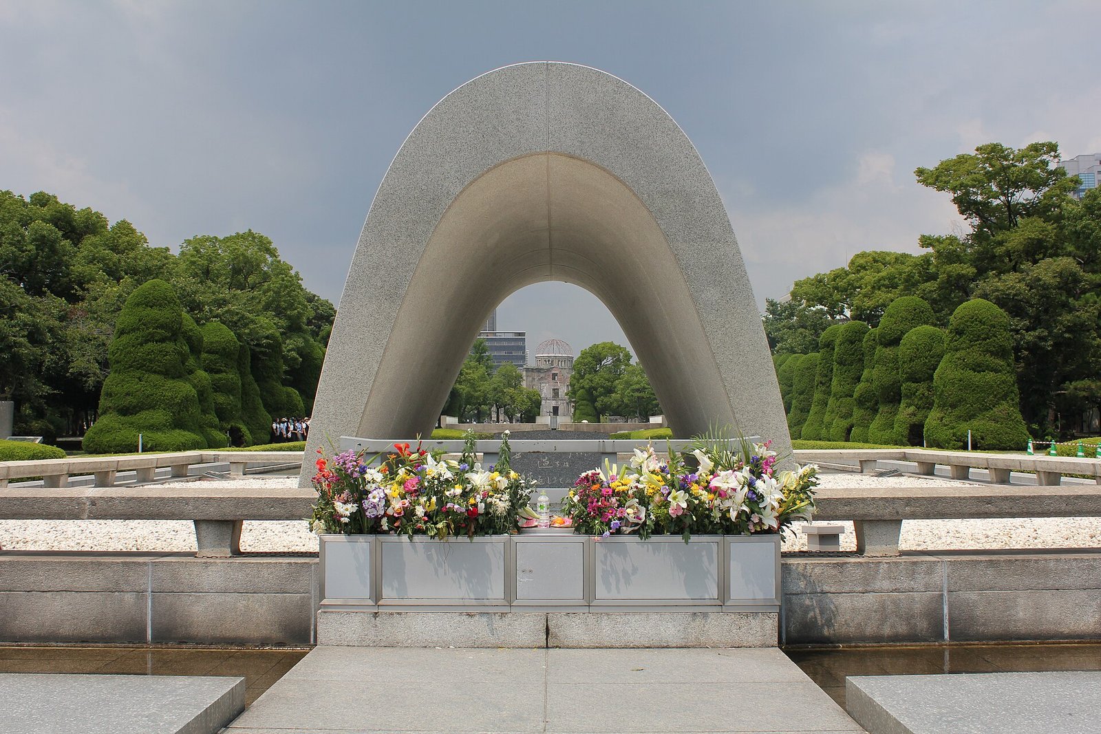 The cenotaph in Hiroshima Peace Memorial Park framing the Atomic Bomb Dome